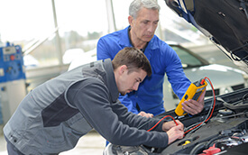 student with teacher reparing a vehicle