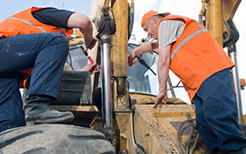 men doing maintenance on mobile machinery
