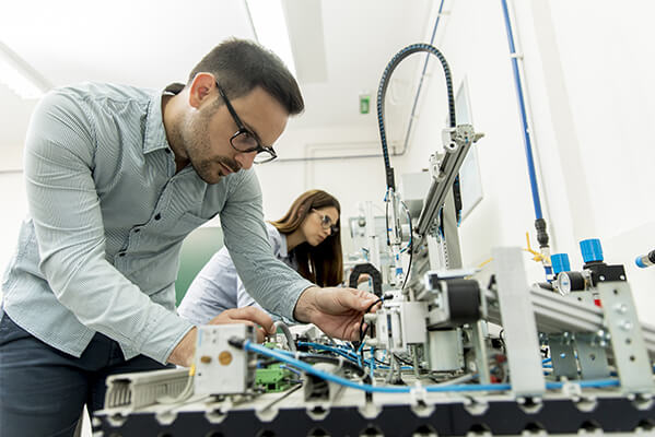 estudantes que operam equipamentos mecatrônicos