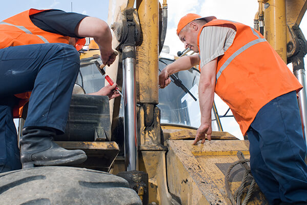 hommes effectuant la maintenance sur une machine mobile