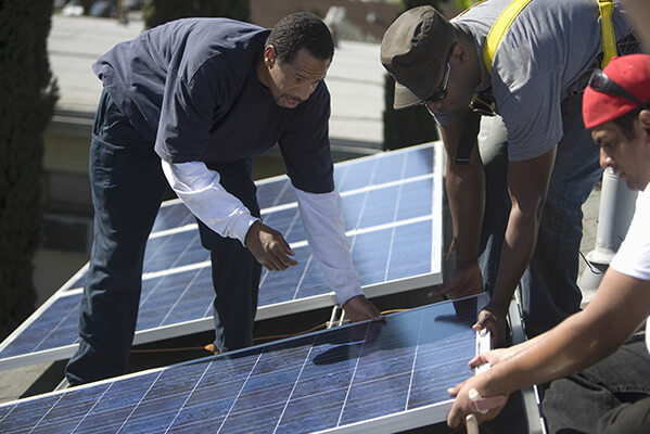 Menschen, die Sonnenkollektoren installieren